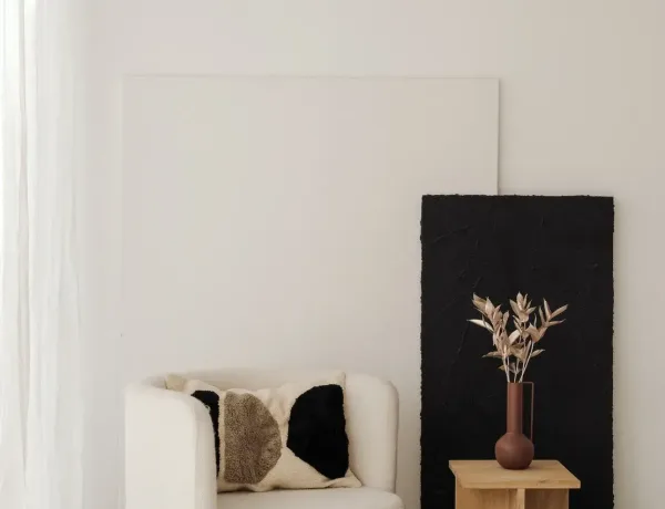 kaboompics_a-cozy-cream-colored-armchair-placed-next-to-minimalist-black-and-white-artwork-with-a-small-side-table-adorned-with-natural-objects-36990